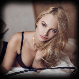 Blonde woman in her underwear posing on a bed with a riding crop